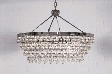 Modern Chandelier Lighting with layers of bubble venetian cristale glass hanging in eight layers and 35 inches across against brick wall
